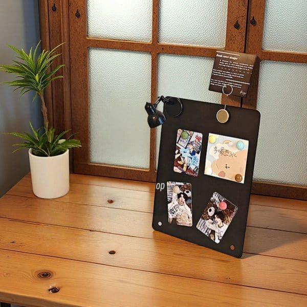 O1CN01jkTGEe2Hf7lxT2vLY_2209056409177-0-cib.jpg Minimalist photo display on black board with colorful pins on wood table, plant, and textured window in background.