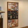 Colorful corkboard with photos, souvenirs, and notes in an office setting.
